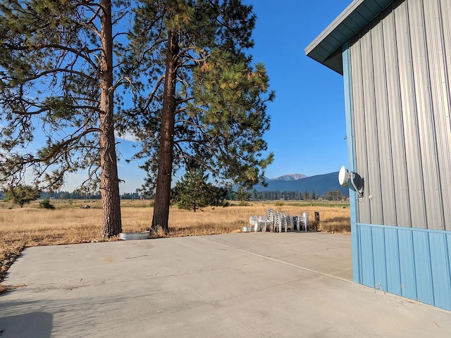 view of patio / terrace with a mountain view and a rural view