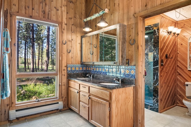 437 Tie Chute Ln, Florence, MT 59833 - full bathroom with baseboard heating, wooden walls, tile patterned floors, double vanity, and toilet