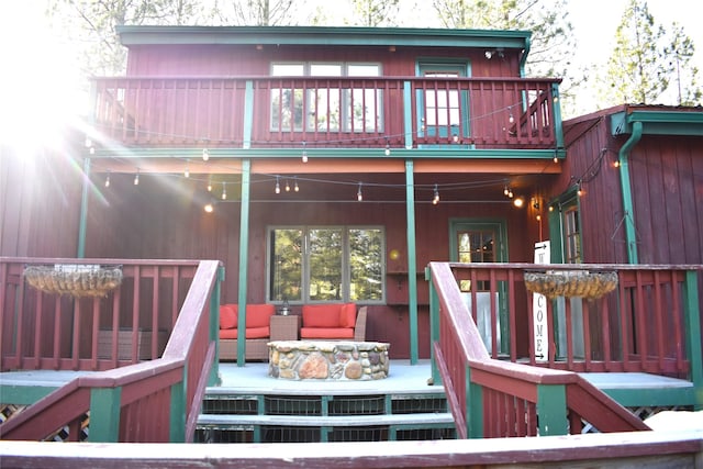 rear view of house with an outdoor living space, a balcony, and a wooden deck