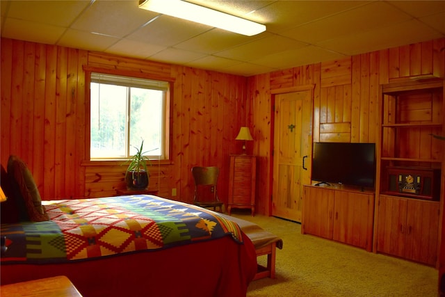 bedroom with carpet and wood walls