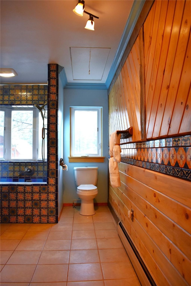 full bathroom featuring crown molding, toilet, a baseboard heating unit, wood walls, and tile patterned flooring