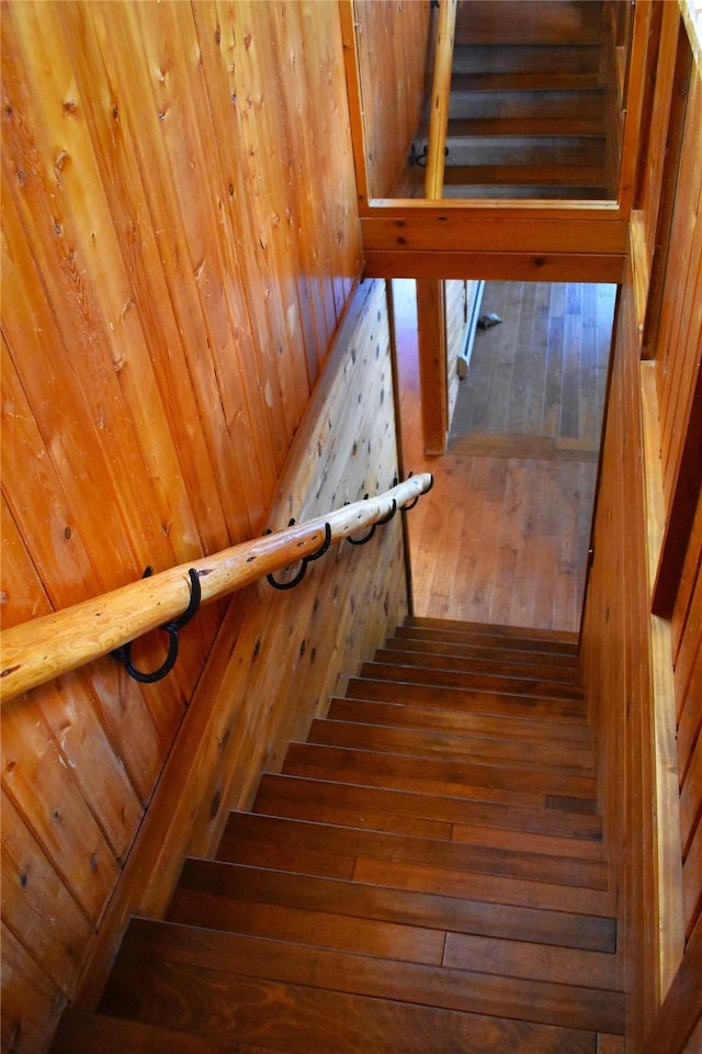 stairway featuring wood walls