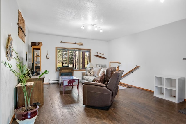 437 Tie Chute Ln, Florence, MT 59833 - living room featuring wood finished floors, baseboard heating, baseboards, and a textured ceiling