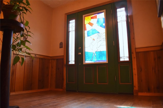 entrance foyer with wainscoting, wood finished floors, and wooden walls