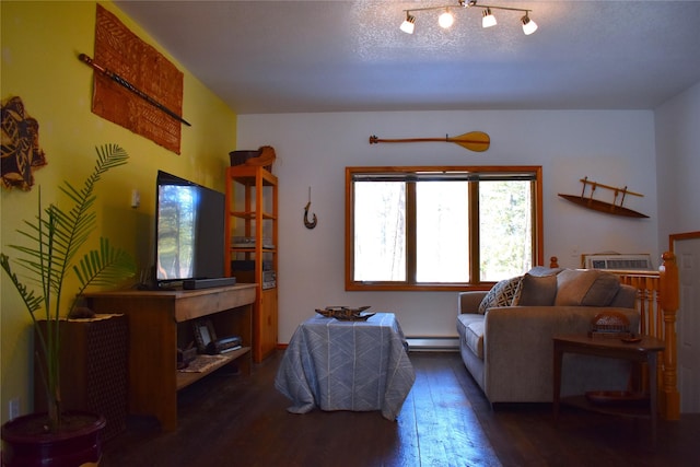 living room with hardwood / wood-style flooring, baseboard heating, a textured ceiling, and a wall mounted air conditioner