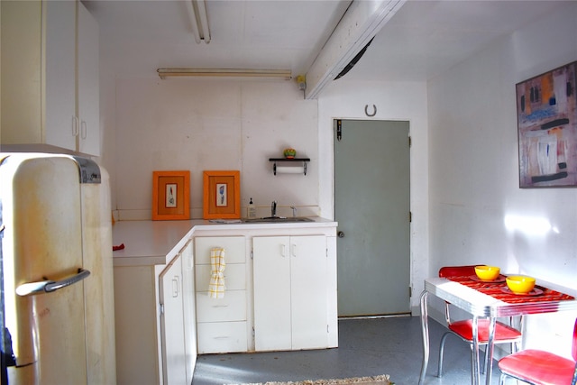 437 Tie Chute Ln, Florence, MT 59833 - kitchen featuring a sink, white cabinetry, light countertops, fridge, and finished concrete floors