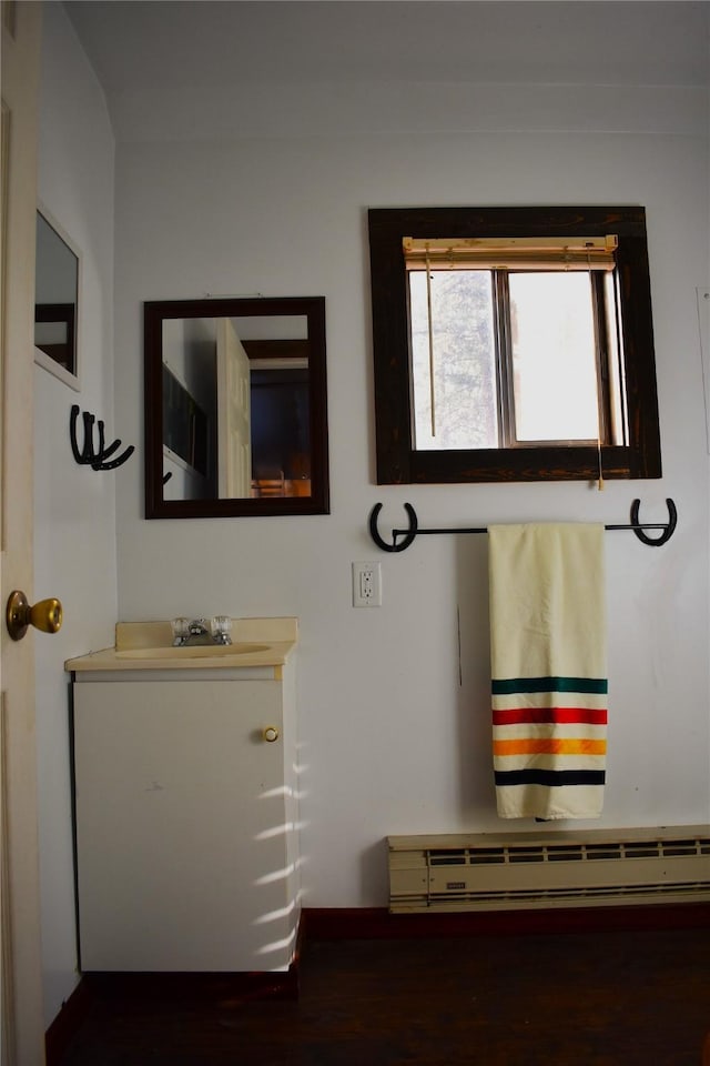 bathroom with vanity, baseboard heating, and wood finished floors