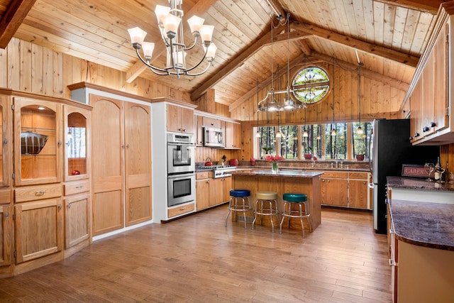 437 Tie Chute Ln, Florence, MT 59833 - kitchen with wood ceiling, appliances with stainless steel finishes, wooden walls, a center island, and hardwood / wood-style floors