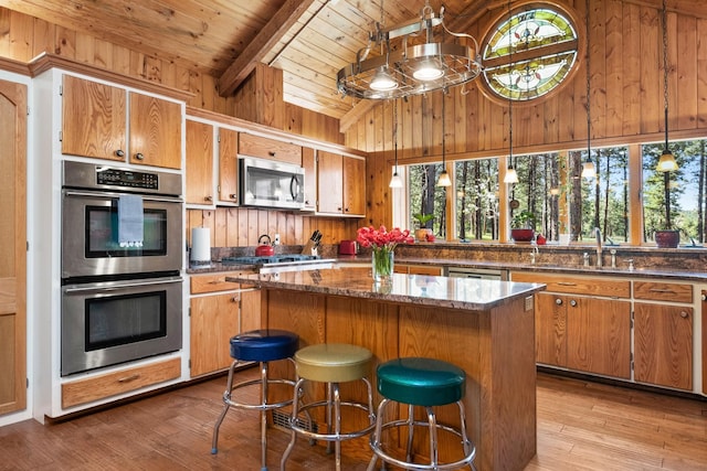 437 Tie Chute Ln, Florence, MT 59833 - kitchen featuring appliances with stainless steel finishes, wood ceiling, wood finished floors, wooden walls, and a kitchen island