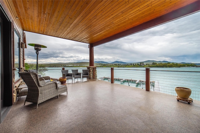 view of patio / terrace with a balcony and a water and mountain view