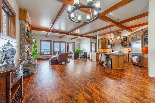 living area with dark wood-style flooring, a notable chandelier, and beamed ceiling