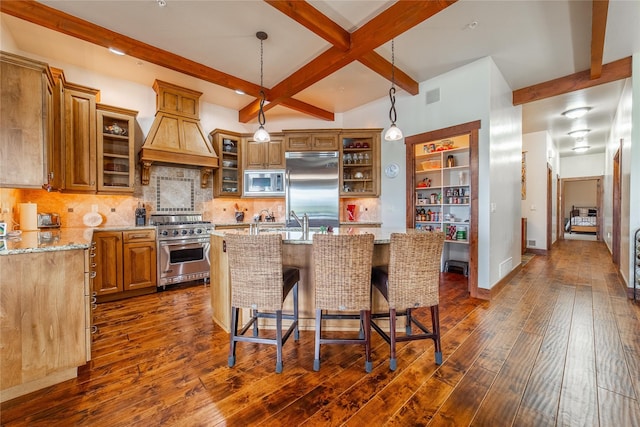 kitchen featuring dark wood-style floors, light stone counters, beam ceiling, decorative backsplash, and built in appliances