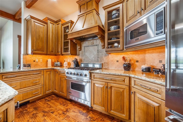 kitchen featuring light stone counters, high end appliances, tasteful backsplash, custom range hood, and dark wood-type flooring