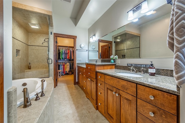 bathroom featuring a stall shower, visible vents, a garden tub, a spacious closet, and vanity