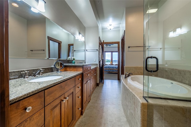 bathroom with tile patterned flooring, ensuite bathroom, a bath, and vanity