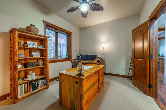 office space featuring a ceiling fan, light carpet, and baseboards