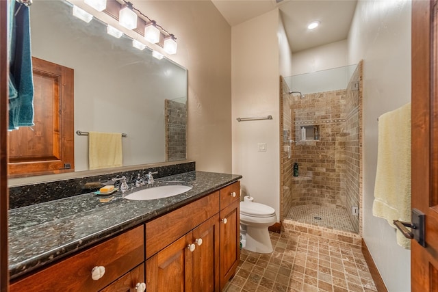 bathroom with vanity, a shower stall, and toilet