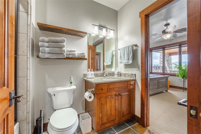 full bathroom with ceiling fan, toilet, vanity, and baseboards