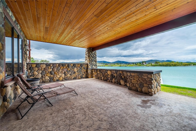 view of patio / terrace featuring a water and mountain view