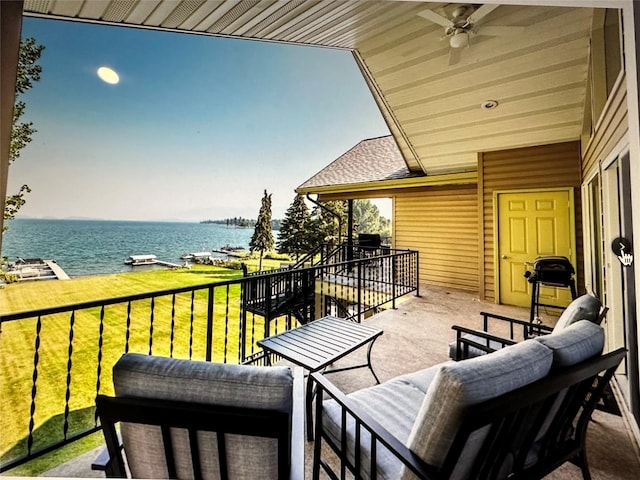 balcony featuring a water view and a ceiling fan