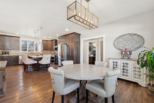 dining room with dark wood-style flooring, a chandelier, and recessed lighting