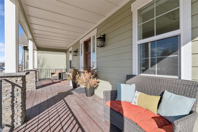 wooden deck with covered porch and an outdoor hangout area