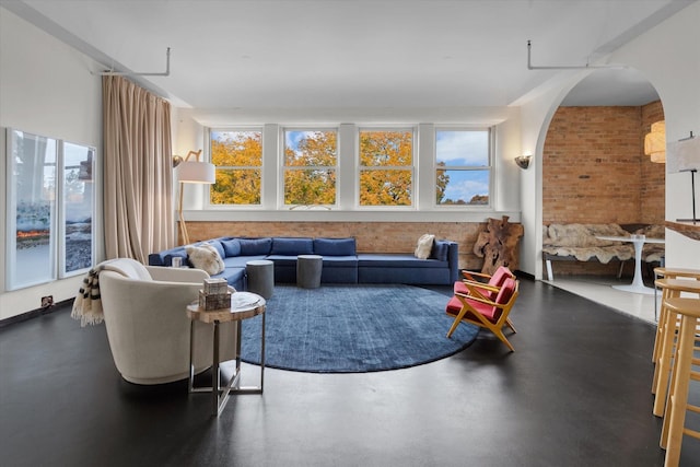 living area featuring concrete flooring and arched walkways