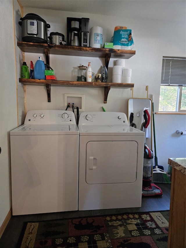 clothes washing area featuring laundry area, washer and clothes dryer, and dark wood finished floors