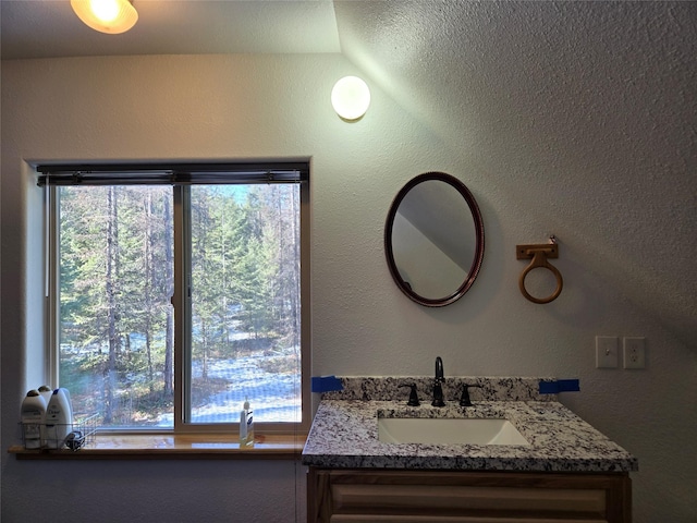 bathroom featuring a textured wall and vanity