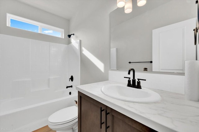 bathroom with bathtub / shower combination, vanity, and toilet