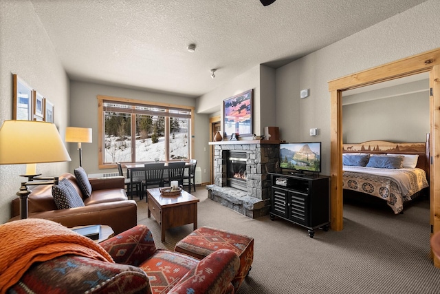 carpeted living area with a textured ceiling, a textured wall, and a fireplace