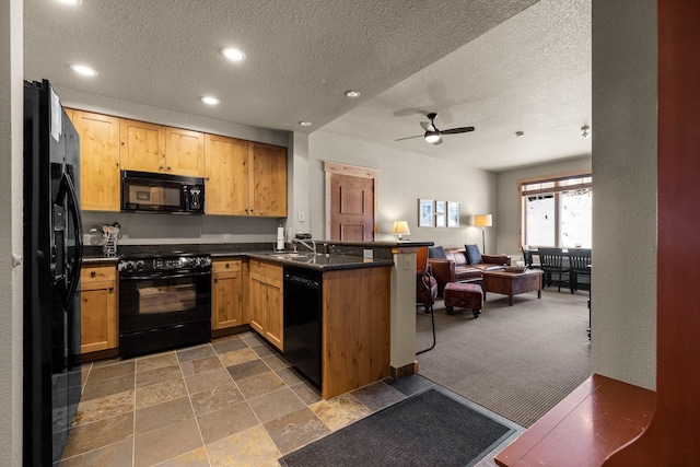 kitchen featuring a peninsula, black appliances, dark countertops, and open floor plan