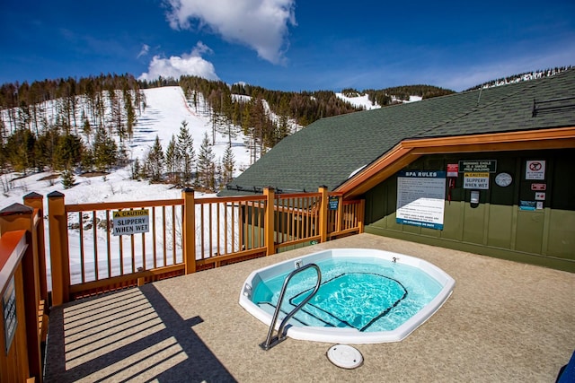 snow covered pool featuring a community hot tub