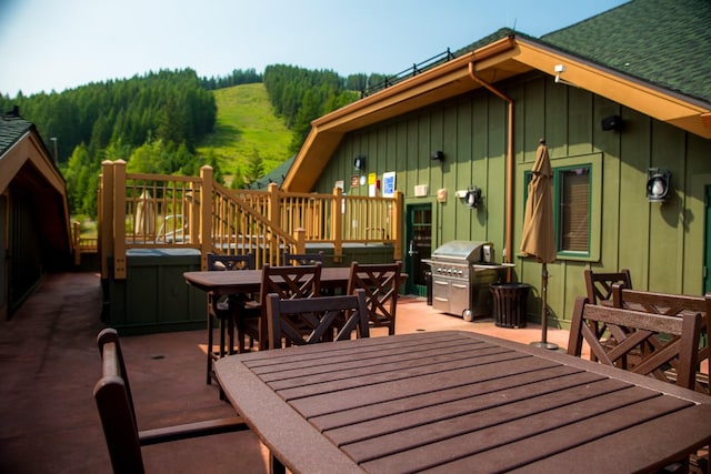 view of patio / terrace with a deck, outdoor dining area, and a grill