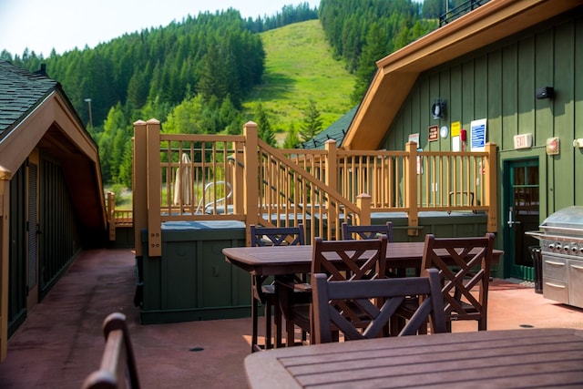 deck featuring a wooded view and outdoor dining space