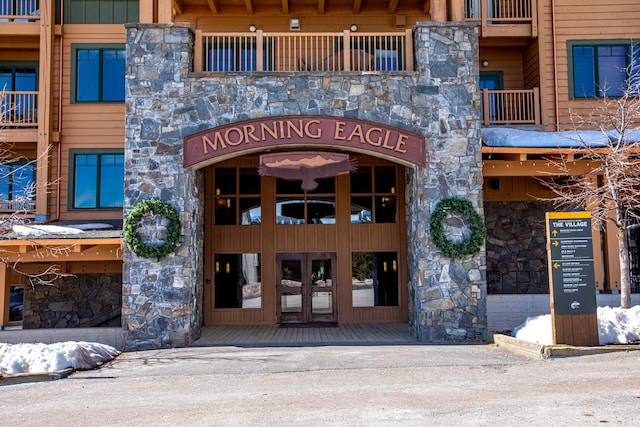 entrance to property featuring stone siding and board and batten siding