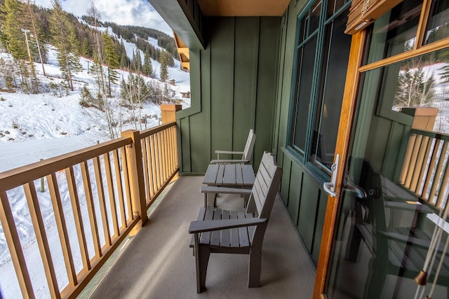 snow covered back of property with a mountain view