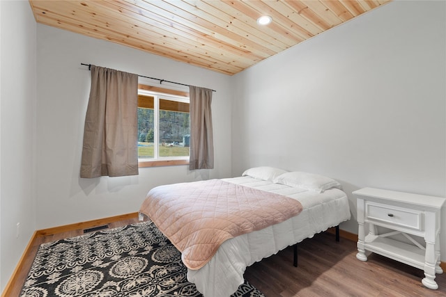 bedroom with baseboards, wood ceiling, visible vents, and wood finished floors