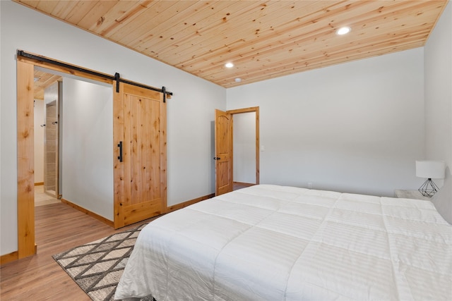 bedroom featuring a barn door, wooden ceiling, wood finished floors, and recessed lighting