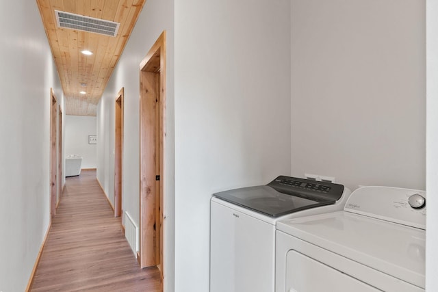 laundry room featuring light wood-type flooring, wood ceiling, visible vents, and separate washer and dryer