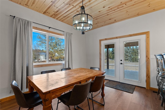 dining area with wood ceiling, a chandelier, wood finished floors, and french doors