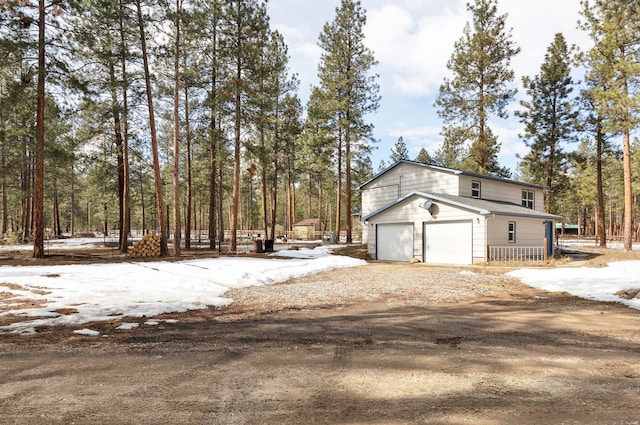 view of side of home with a garage and dirt driveway