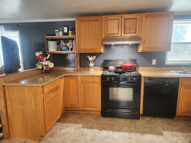 kitchen with a peninsula, black appliances, extractor fan, and a sink