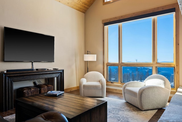 living area featuring baseboards, vaulted ceiling, and wood finished floors