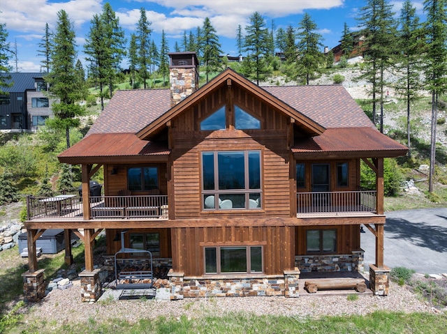 476 Elk Highlands Dr, Whitefish, MT 59937 - rear view of property with a balcony, board and batten siding, a chimney, and roof with shingles