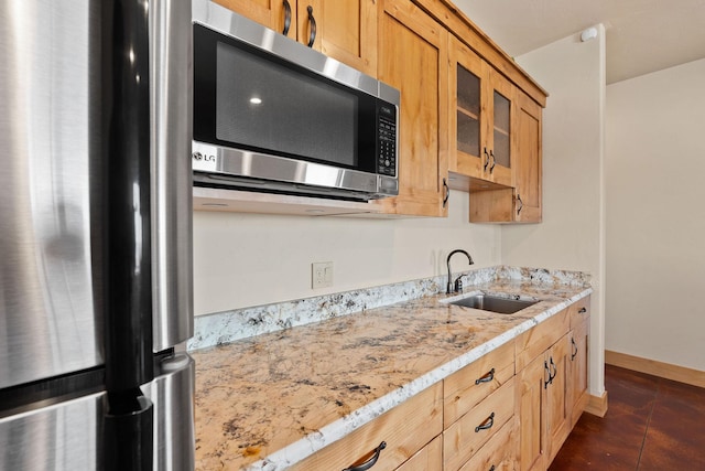 476 Elk Highlands Dr, Whitefish, MT 59937 - kitchen with a sink, stainless steel appliances, glass insert cabinets, baseboards, and light stone countertops