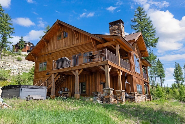 476 Elk Highlands Dr, Whitefish, MT 59937 - rear view of house with board and batten siding, a chimney, a deck, and stairs