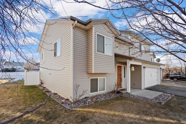 view of front of home with a garage, a front yard, and driveway