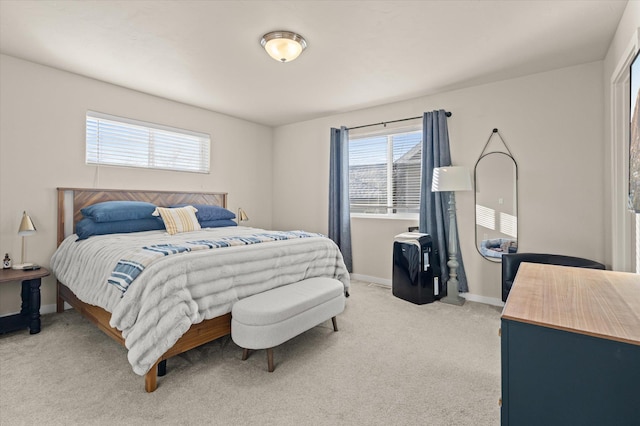 bedroom featuring light carpet and baseboards