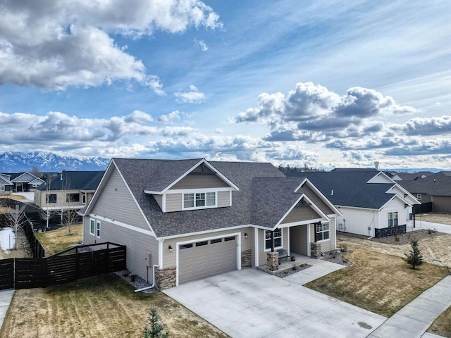 154 W Swift Creek Way, Kalispell, MT 59901 - craftsman house featuring roof with shingles, concrete driveway, stone siding, a garage, and a residential view
